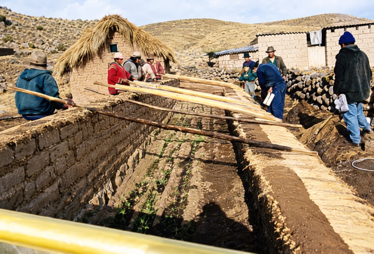 People working around a masonry structure with wooden beams