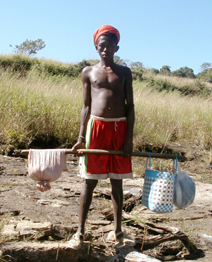 A young person carrying buckets suspended from a wooden pole
