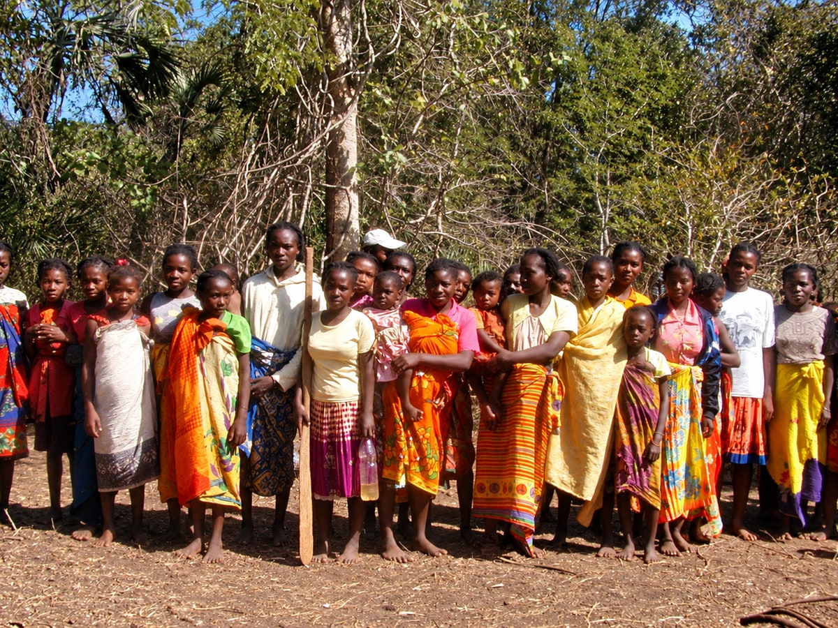 A group of people standing outdoors in brightly coloured wraps