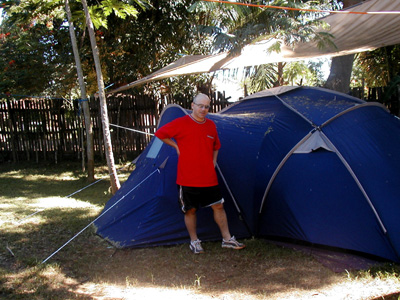 Danilo Barbero beside a large blue tent under trees