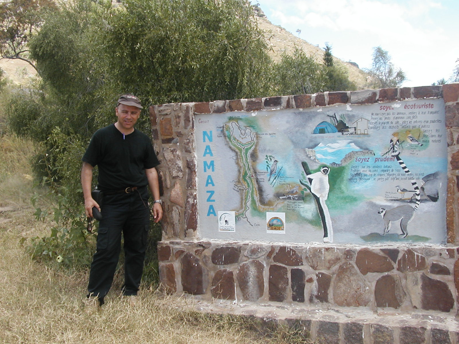 Danilo Barbero beside an illustrated Namaza visitor information board