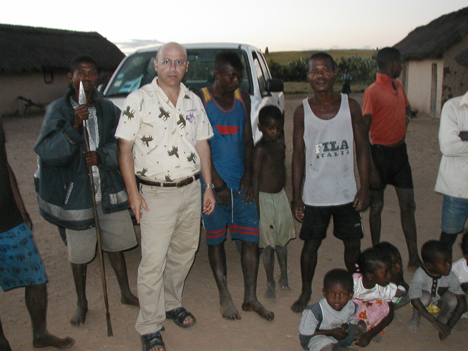Danilo Barbero and residents gathered near a vehicle in a village
