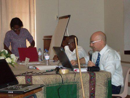 Danilo Barbero speaking into a microphone at a workshop table with colleagues